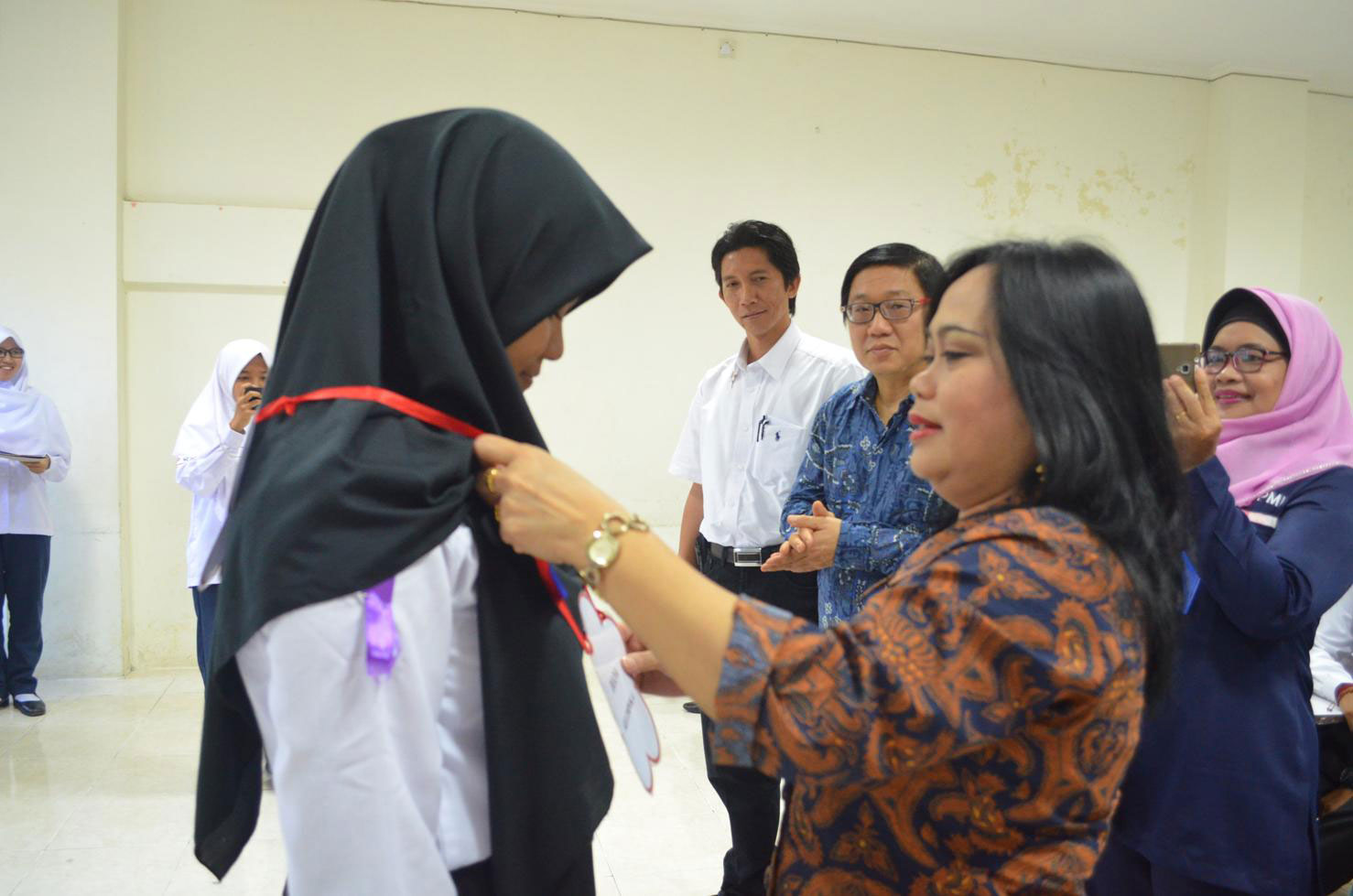 Dekan FKM Hanifa Maher Denny mengalungkan tanda peserta kepada perwakilan KSR PMI sebagai tanda dimulainya kegiatan Pendidikan dan Pelatihan 120 Jam Bagi Calon Anggota Korps Sukarela (KSR) PMI Unit FKM UNDIP, Rabu (1/02) di Kampus FKM Undip Tembalang.
